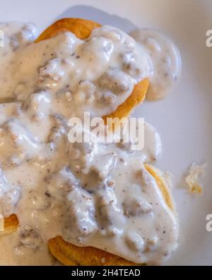 Sauce au lait poivrée à la saucisse sur des biscuits sur une assiette blanche. Banque D'Images