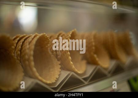 Cornets alvéolés pour la glace.Bonbons sur la fenêtre du magasin.Plats délicieux.Gaufres cuites au four. Banque D'Images