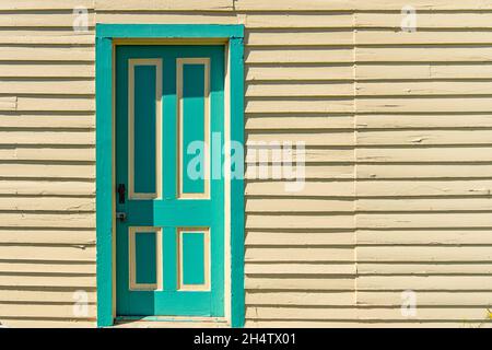 Ancienne porte peinte jaune et verte avec parement horizontal en panneau de protection Banque D'Images