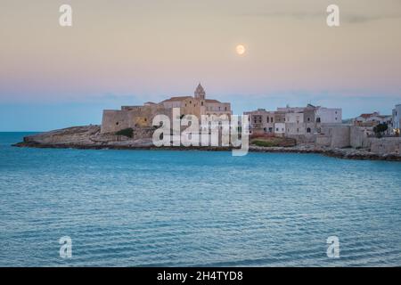 Vue agréable sur la vieille ville de Vieste au crépuscule, église sur les rochers à Gargano, Apulia, Italie du Sud Banque D'Images