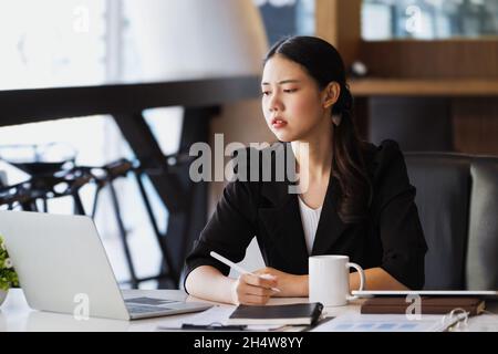 Les employés de l'entreprise se montrent ennuyés par un travail inachevé utilisant un ordinateur portable, des documents et des tablettes au travail. Banque D'Images