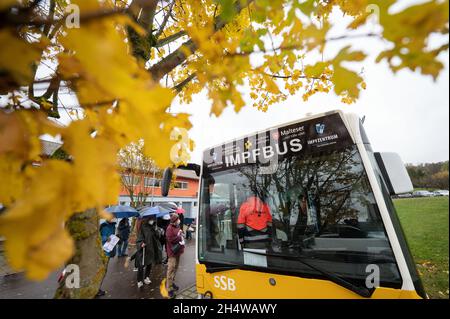 Notzingen, Allemagne.04e novembre 2021.Les gens attendent en ligne avec des parapluies devant un bus de vaccination.Credit: Marijan Murat/dpa/Alamy Live News Banque D'Images