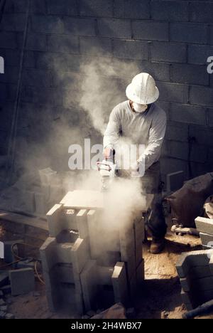 Mason Cutting bloc de béton à l'aide d'une scie circulaire Banque D'Images