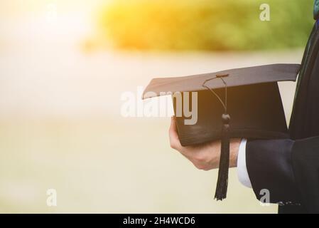 Gros plan diplômé tenant un chapeau.Concept réussite éducation à l'université avec espace de copie. Banque D'Images