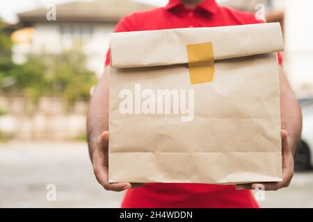 Postman dans un emballage de maintien uniforme rouge. Banque D'Images