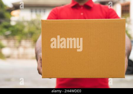 Postman dans un emballage de maintien uniforme rouge. Banque D'Images