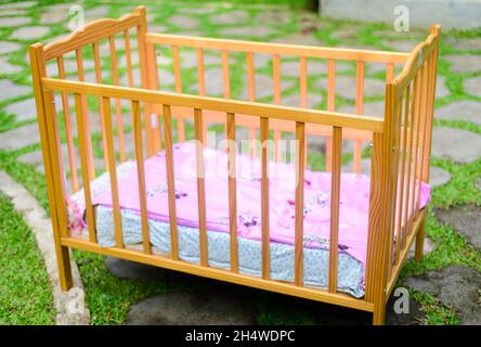 Lit bébé avec matelas doux et draps confortables, finition en bois élégante sur le lit. Banque D'Images