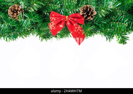 Large bordure de Noël en forme de arche isolée sur blanc, composée de branches et de cônes de sapin et d'un arc rouge.Copier l'espace pour le texte Banque D'Images
