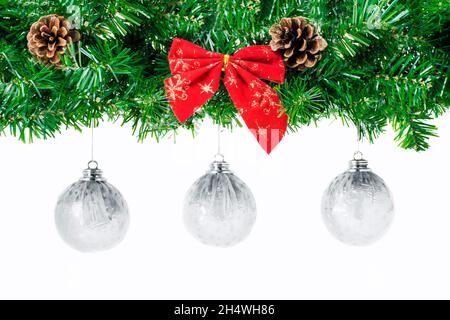 Large bordure de Noël en forme de arche avec boules de noël blanches suspendues, isolées sur blanc, composées de branches et de cônes de sapin et d'un noeud rouge.Copier l'espace pour Banque D'Images