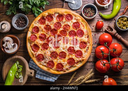 Pizza au pepperoni maison sur une table en bois, vue de dessus, gros plan Banque D'Images