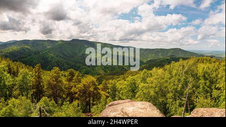 Panorama des collines verdoyantes par beau temps d'été.Belle vue sur les montagnes couvertes de verdure sur fond de nuages.Route de campagne Banque D'Images