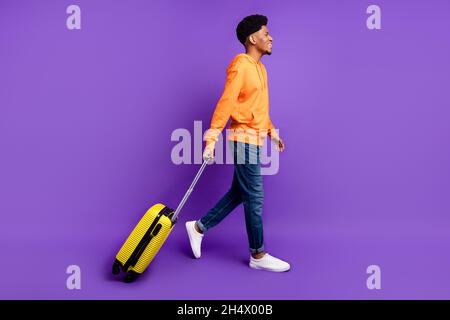 Profil de la taille de la carrosserie vue latérale d'un joli gars gai Going bag isolé sur fond violet vif de couleur violet Banque D'Images