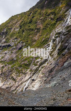 Pierres, glace et petite cascade.Glacier Franz Joseph.Île du Sud, Nouvelle-Zélande Banque D'Images