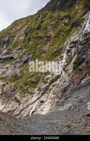 Pierres, glace et petite cascade.Glacier Franz Joseph.Île du Sud, Nouvelle-Zélande Banque D'Images