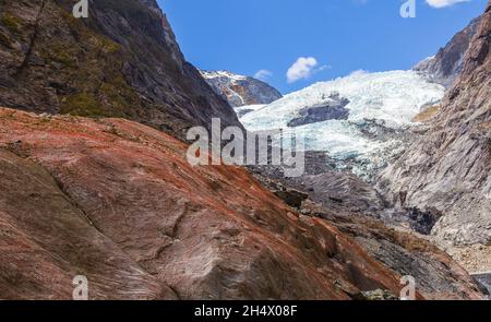 Rocher rouge sur fond de glacier.Glacier Franz Joseph, Nouvelle-Zélande Banque D'Images