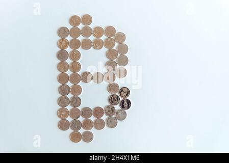 Alignement des pièces de baht thaïlandais sur le symbole baht thaïlandais sur fond blanc. Banque D'Images