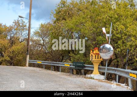 Temple en bord de route, chapelle commémorative en Grèce sur une route de montagne dangereuse tourner avec miroir installé sur le côté de la route.Village éloigné sur Lefkada i Banque D'Images