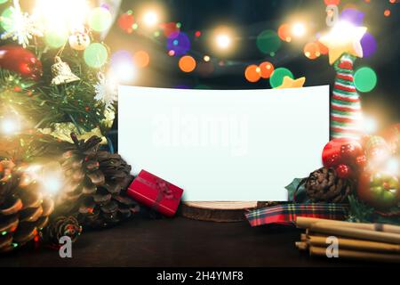 Joyeux Noël et un concept du nouvel an heureux, avec un ornement décoré, une boîte cadeau, un arbre de Noël, des cônes de pin, un éclairage et un espace papier blanc Banque D'Images