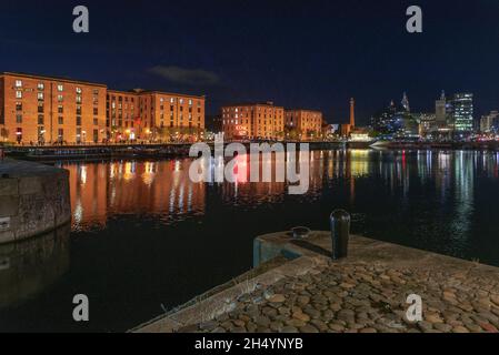 Albert Dock de Liverpool vu à travers Canning Dock la nuit avec la tête de perce et le bâtiment du foie en arrière-plan. Banque D'Images