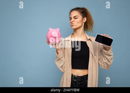 Portrait photo de insatisfait douteux jeune belle brune belle femme avec des émotions sincères portant élégant beige chemise isolée Banque D'Images