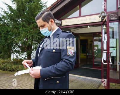 05 novembre 2021, Hessen, Büdingen: L'attaché de presse de la police, Tobias Kremp, se trouve cet après-midi devant le Wolfgang Konrad Hall, dans le quartier de Lorbach, avec un tube à essai.Dans la recherche de la mère d'un nourrisson mort trouvé en 1999, un examen en série de l'ADN aura lieu ici à partir de samedi (06.11.2021).Les enquêteurs espèrent faire des progrès dans la résolution de l'homicide présumé.Environ 600 femmes de la région entourant la ville dans le district de Wetterau, qui avaient entre 13 et 30 ans quand le corps a été trouvé, ont été invitées à donner volontairement un échantillon de salive.Photo: Frank Rumpenhorst/dpa Banque D'Images