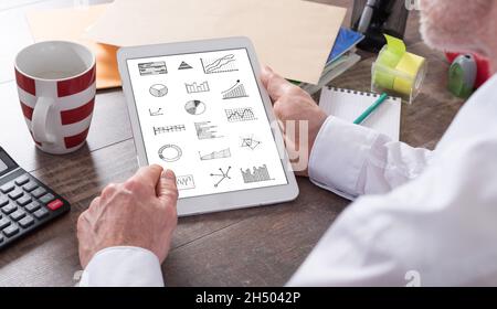 Concept d'analyse graphique affiché sur un écran de tablette tenu par un homme Banque D'Images