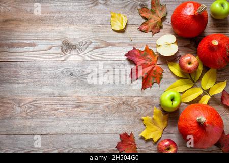 Bordure d'automne des pommes, de la citrouille et des feuilles tombées sur une ancienne table en bois.Concept de jour de Thanksgiving.Citrouille de Thanksgiving avec fruits.Fruits et légumes Banque D'Images