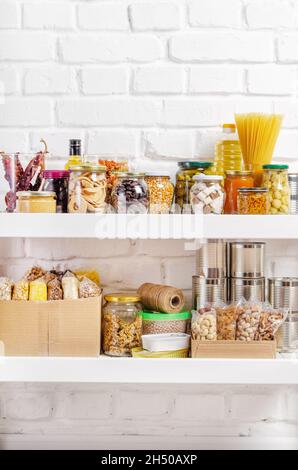 Ensemble de nourriture longue durée de stockage sur la tablette de garde-manger préparée pour les conditions d'urgence de catastrophe sur fond de mur de brique Banque D'Images