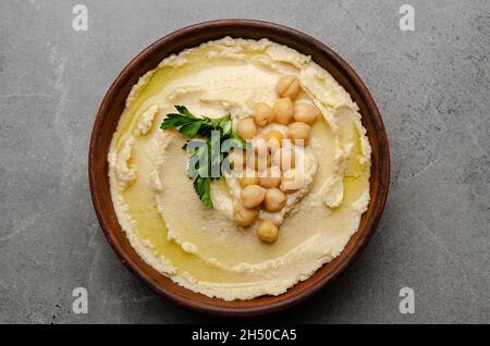 Vue plate sur l'humus surmontée de pois chiches et de feuilles de coriandre verte sur la table en pierre Banque D'Images