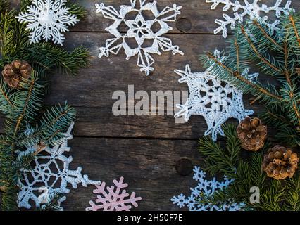 décorations en forme de flocon de neige en crochet sur sol en bois avec espace pour le texte et branche de sapin et fond de cônes Banque D'Images