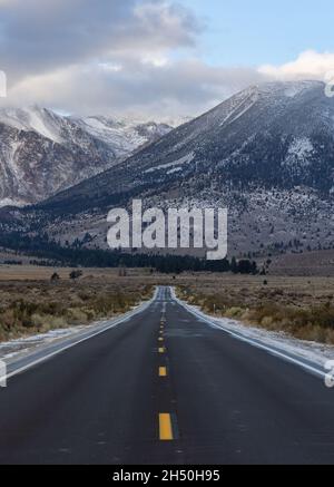 L'autoroute mène aux montagnes enneigées de l'est de la sierra Banque D'Images