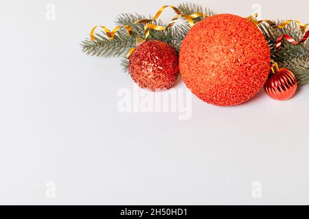 Décorations de Noël de boules rouges avec branches d'épinette sur fond blanc.Copier l'espace Banque D'Images