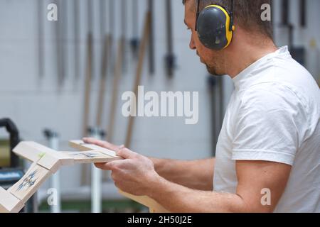 Un homme fait des meubles sur mesure dans un atelier de travail du bois montrant le processus de construction Banque D'Images
