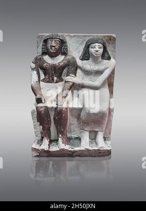 Statue égyptienne sculpture d'un couple assis, 2350-2200, 6e dynastie, tombeau de mastaba d'ISI.Musée du Louvre E14399. Femme assise avec une robe, évasée wi Banque D'Images