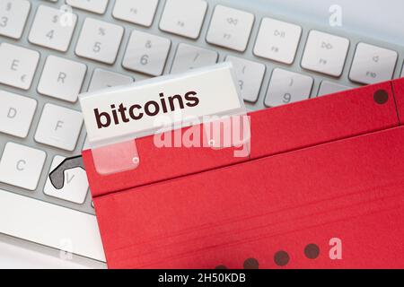 le dossier de suspension rouge d'un clavier comporte un onglet avec le mot bitcoins Banque D'Images