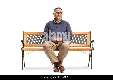Homme mûr souriant avec des lunettes assises sur un banc isolé sur fond blanc Banque D'Images