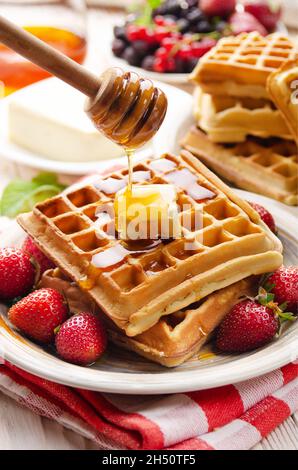 Gaufres belges servies avec du beurre, des fraises et du miel Banque D'Images