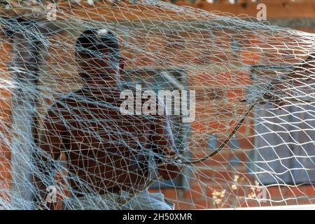 Salvador, Bahia, Brésil - 29 novembre 2014 : le pêcheur répare le filet de pêche après une période d'utilisation intensive. Banque D'Images