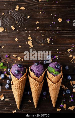 Plan de pose vue sur les cônes de cachets avec glace blackberry sur une table de cuisine en bois Banque D'Images