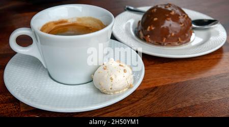 Délicieux caffee americano avec une meringue sucrée à part et un petit gâteau au chocolat et aux noix, rituel de l'après-midi en famille et entre amis Banque D'Images