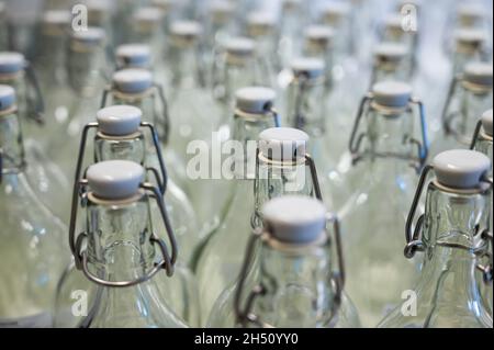 Un gros plan du col d'une bouteille.Groupe de bouteilles vides avec bouchons en plastique dans un magasin sur le comptoir. Banque D'Images