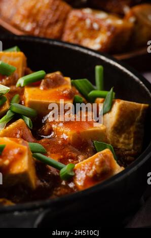 Mapo tofu dans une poêle en fonte avec ciboulette hachée de porc sauce soja poivre du sichuan ail et épices Banque D'Images