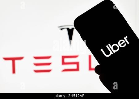 Tachkent, Ouzbékistan - 29 octobre 2021 : une personne détient un smartphone avec la marque Uber et le logo Tesla.Les grèves d'Uber ont un accord avec Tesla to Banque D'Images