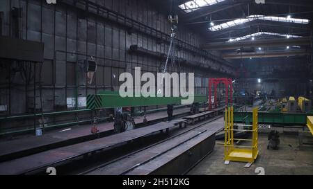 Pont roulant à poutre en I.Attache.Entrepôt avec de grandes poutres métalliques jaunes.Entrepôt industriel avec poutres principales et chariot de pont roulant. Banque D'Images