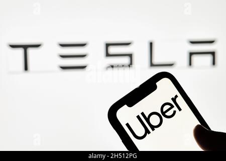 Tachkent, Ouzbékistan - 29 octobre 2021 : une personne détient un smartphone avec la marque Uber et le logo Tesla.Les grèves d'Uber ont un accord avec Tesla to Banque D'Images