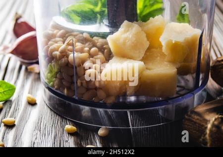 Ingrédients pour la sauce au pesto génovese traditionnelle italienne dans les aliments bol du processeur Banque D'Images