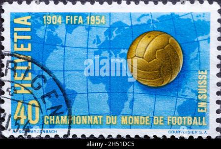 Suisse - Circa 1954 : timbre-poste imprimé en suisse montrant une balle de football et une carte du monde (coupe du monde de football 1954 à Lausanne et Berne Banque D'Images