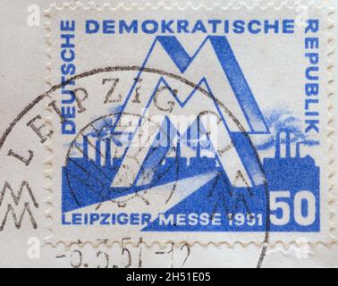 ALLEMAGNE, DDR - VERS 1951 : timbre-poste de l'Allemagne, RDA montrant une marque « M » devant une usine industrielle.Foire de printemps de Leipzig 1951 Banque D'Images