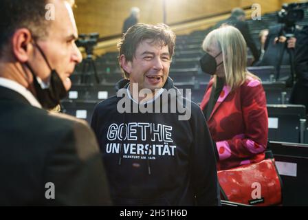 Francfort, Allemagne.05ème novembre 2021.05 novembre 2021, Hessen, Francfort-sur-le-main : le lauréat Christian Drosten (M) de la soirée se tient dans l'Audimax de l'hôpital universitaire de Francfort après avoir reçu le Prix de la culture hessienne, portant un sweat-shirt à capuche portant l'inscription Goethe « Université de Francfort-sur-le-main », que le Premier ministre de Hesse, Bouffier, lui avait précédemment présenté.Photo: Frank Rumpenhorst/dpa crédit: dpa Picture Alliance/Alay Live News Banque D'Images