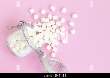 petits guimauves blanches dans un pot avec espace pour le texte sur fond rose et festif Banque D'Images